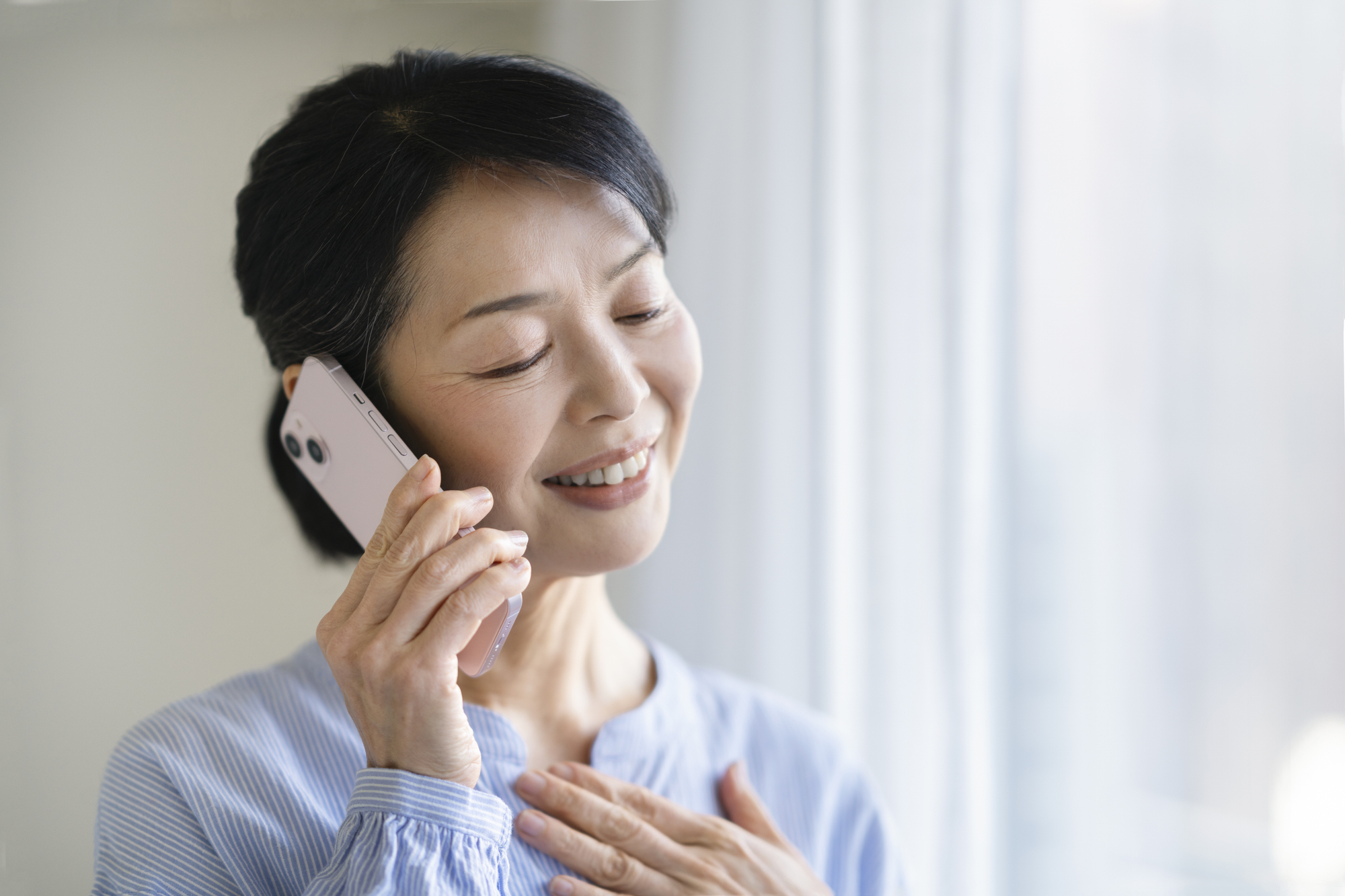 電話で相談して安心する女性のイメージ写真